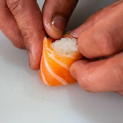 Chef do Sushi & Restaurante Nakaza a moldar sushi artesanalmente com salmão e arroz