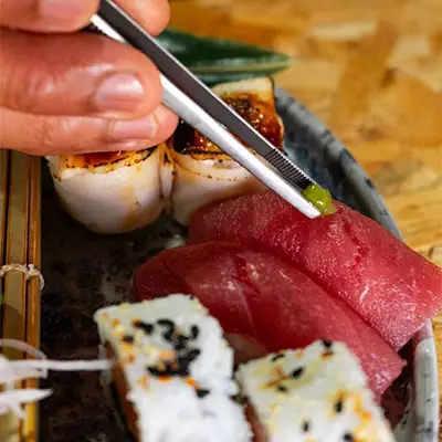 Aplicação de wasabi em sashimi pelo chef no Sushi & Restaurante Nakaza, durante a preparação do prato
