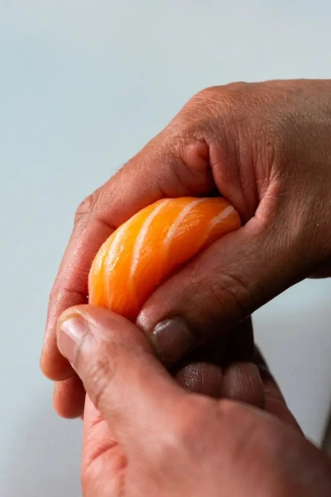 Chef do Sushi & Restaurante Nakaza a moldar sushi artesanalmente com salmão e arroz