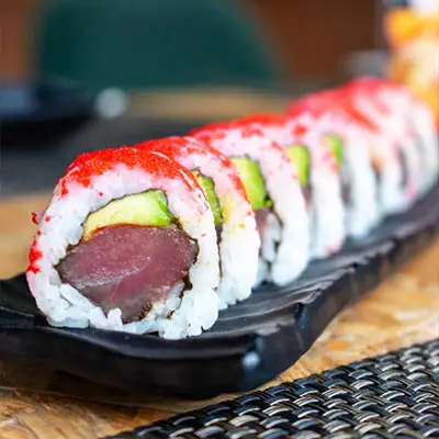 Roll de sushi do Sushi & Restaurante Nakaza com atum, abacate e cobertura crocante, servido em travessa preta
